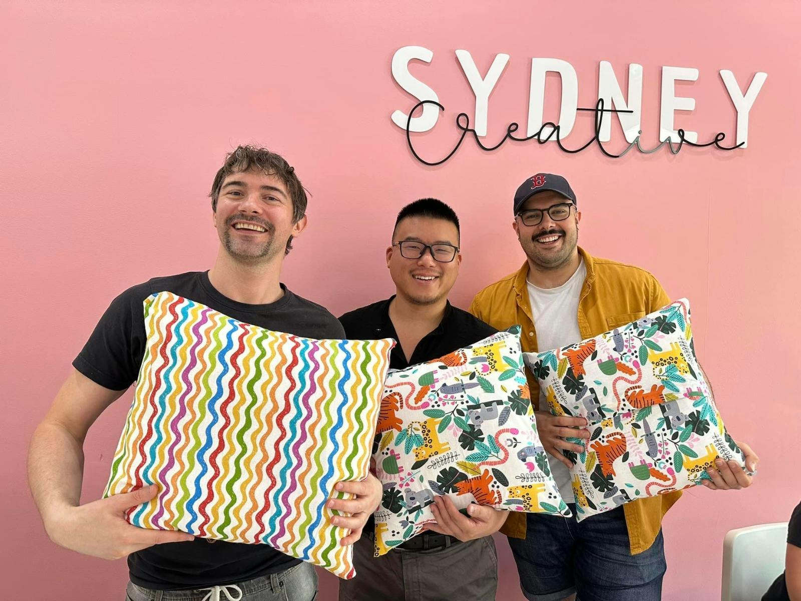 Participants holding cushions made during our Sewing For Beginners class